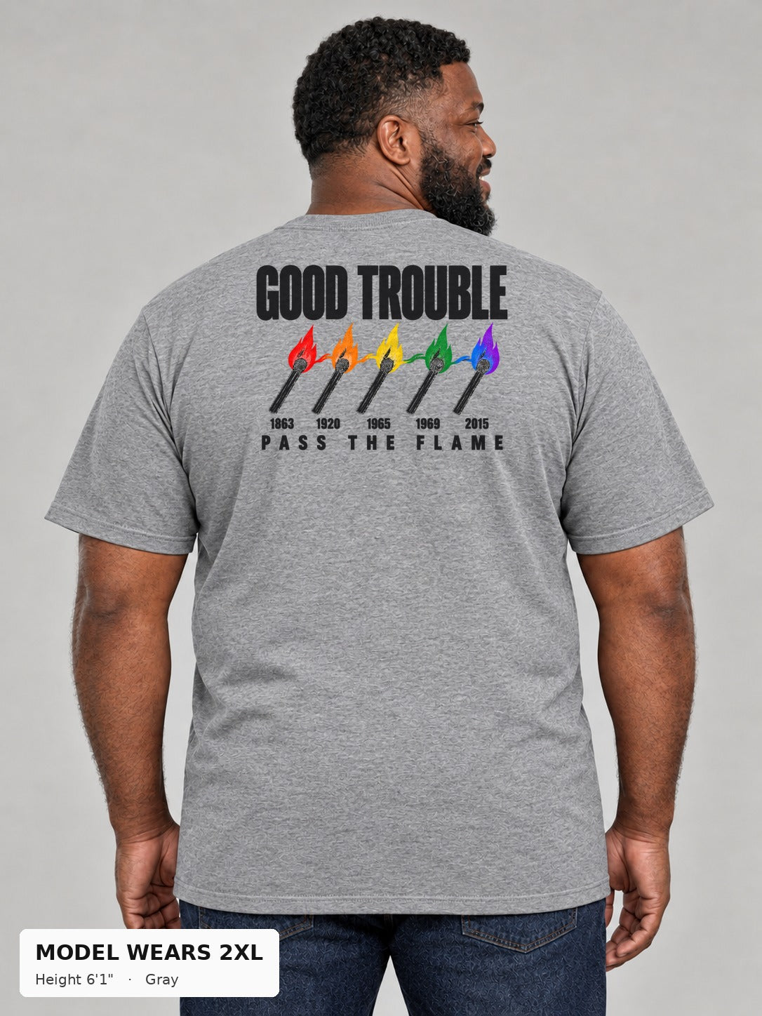 Good Trouble Pass the Flame Tee in Gray, back view showing the PASS THE FLAME five-match back print, on a plus-size model wearing size 2XL, 6'1" - Good Trouble Fashion