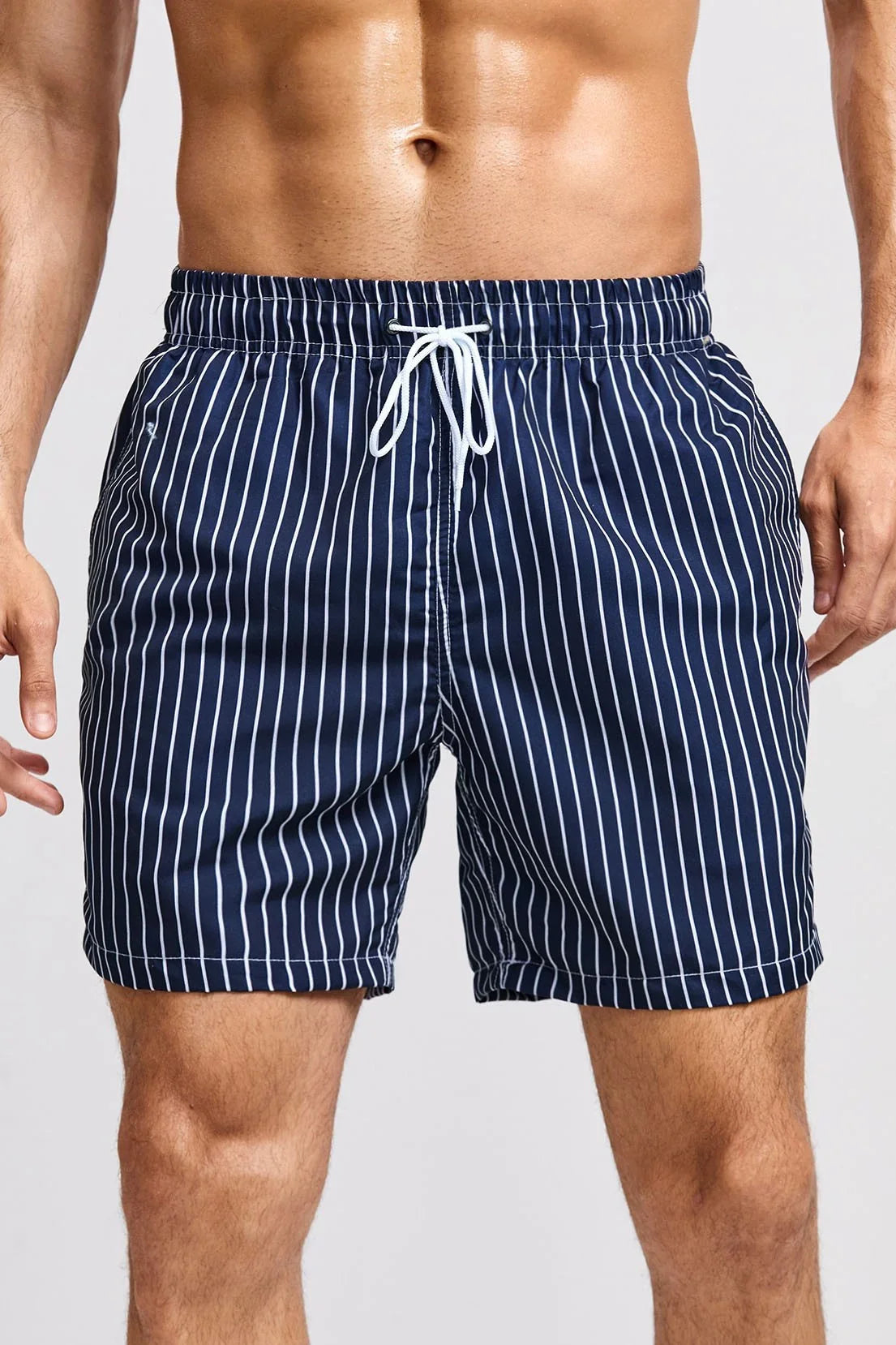 Good Trouble Garments men's striped swim shorts in navy blue with white vertical stripes and drawstring waist