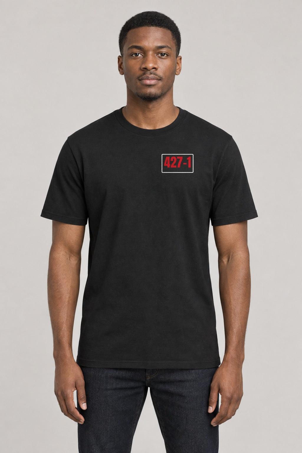 427–1 Release the Epstein Files Tee in Black, front view showing the 427–1 left-chest badge, on an athletic model wearing size L, 6'0" - Good Trouble Fashion