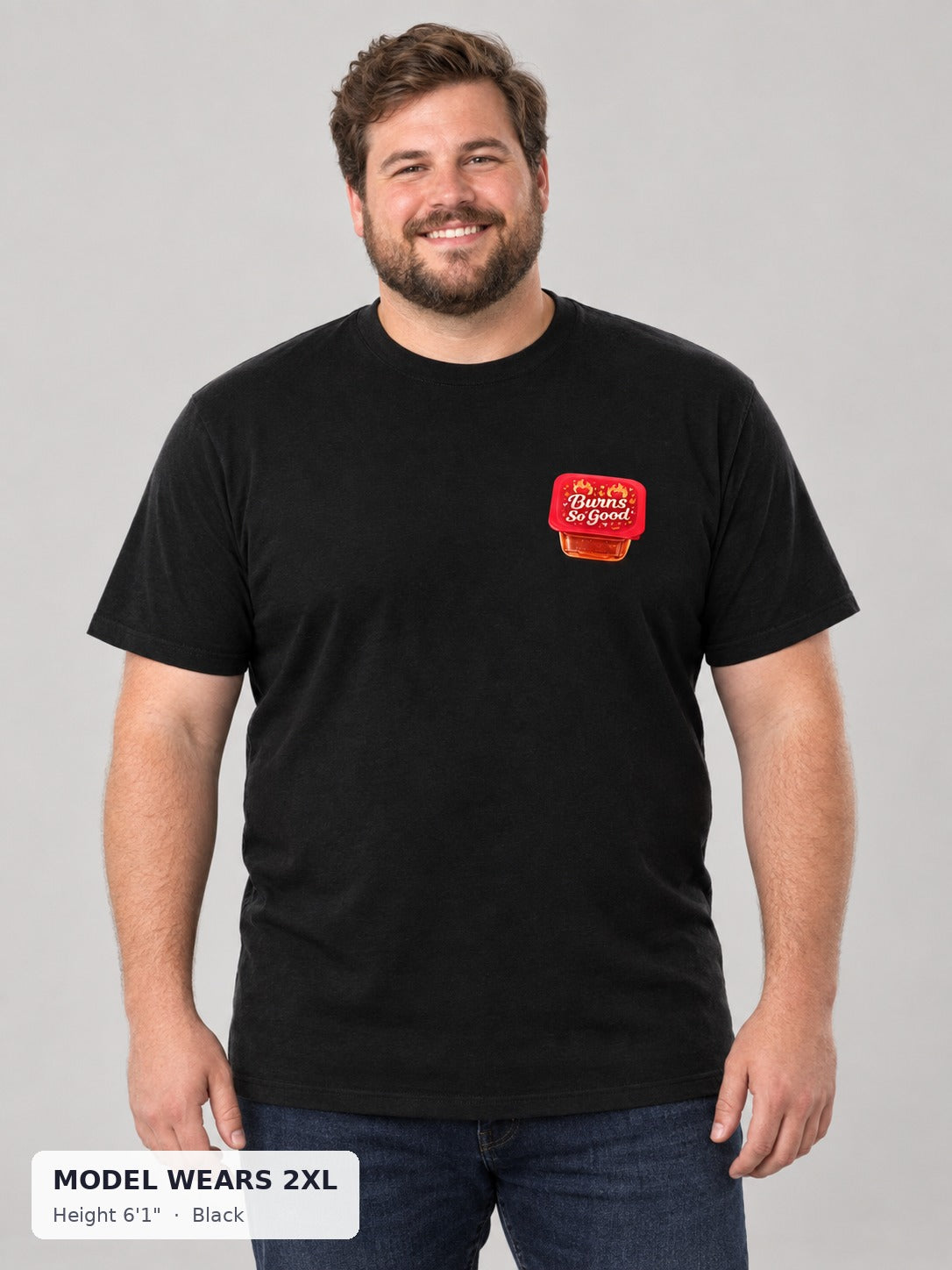 Burns So Good Hot Sauce Tee in Black on a plus-size model wearing size 2XL, 6'1" - Good Trouble Fashion