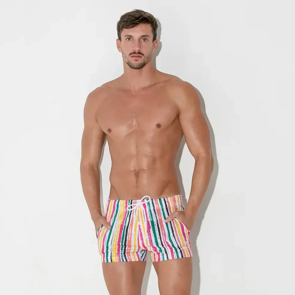 Man wearing CODE 22 branded swimwear with colorful striped design for stylish summer outings