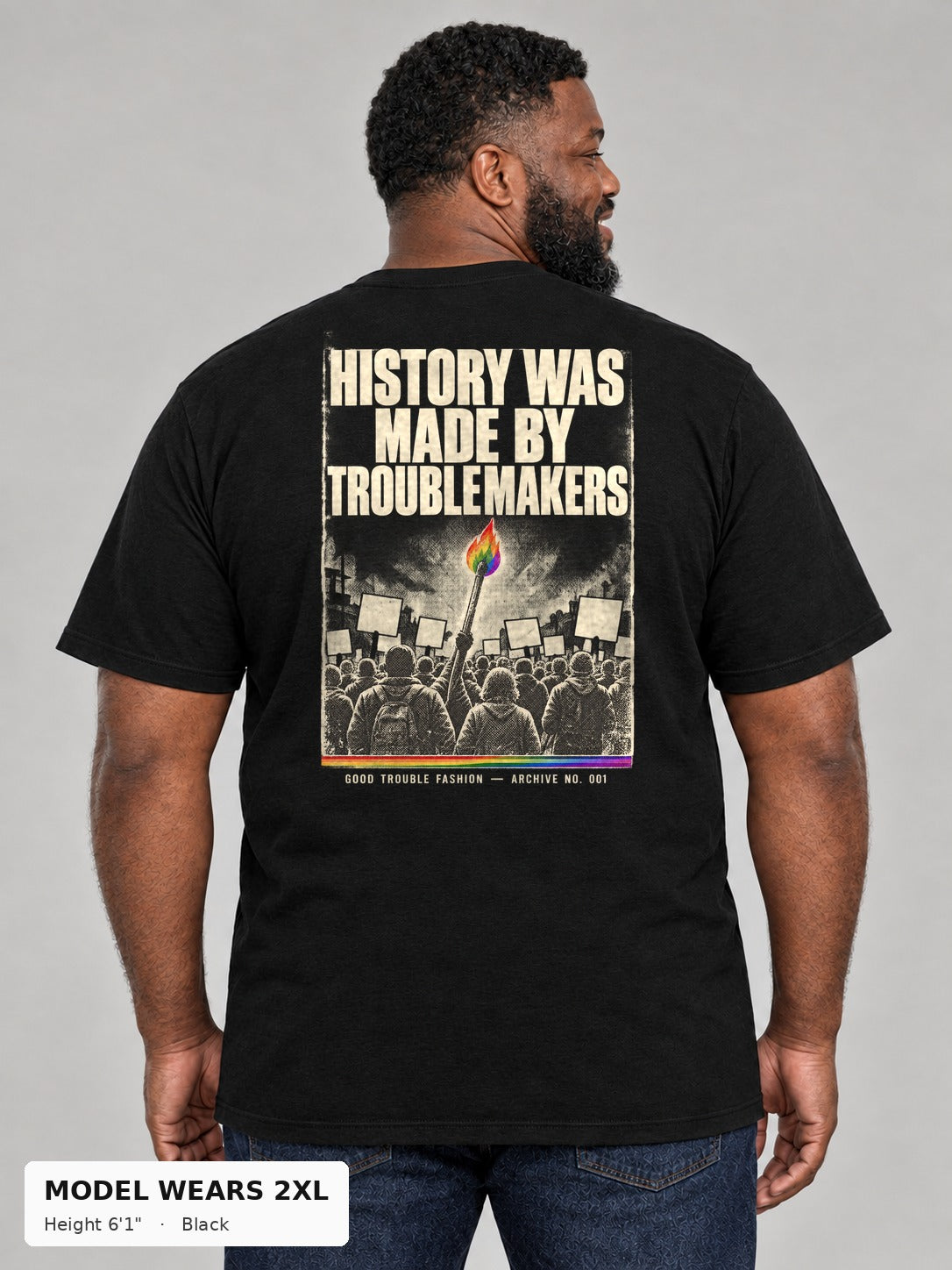 Good Trouble Archive 001 Tee in Black, back view showing the HISTORY WAS MADE BY TROUBLEMAKERS poster back print, on a plus-size model wearing size 2XL, 6'1" - Good Trouble Fashion