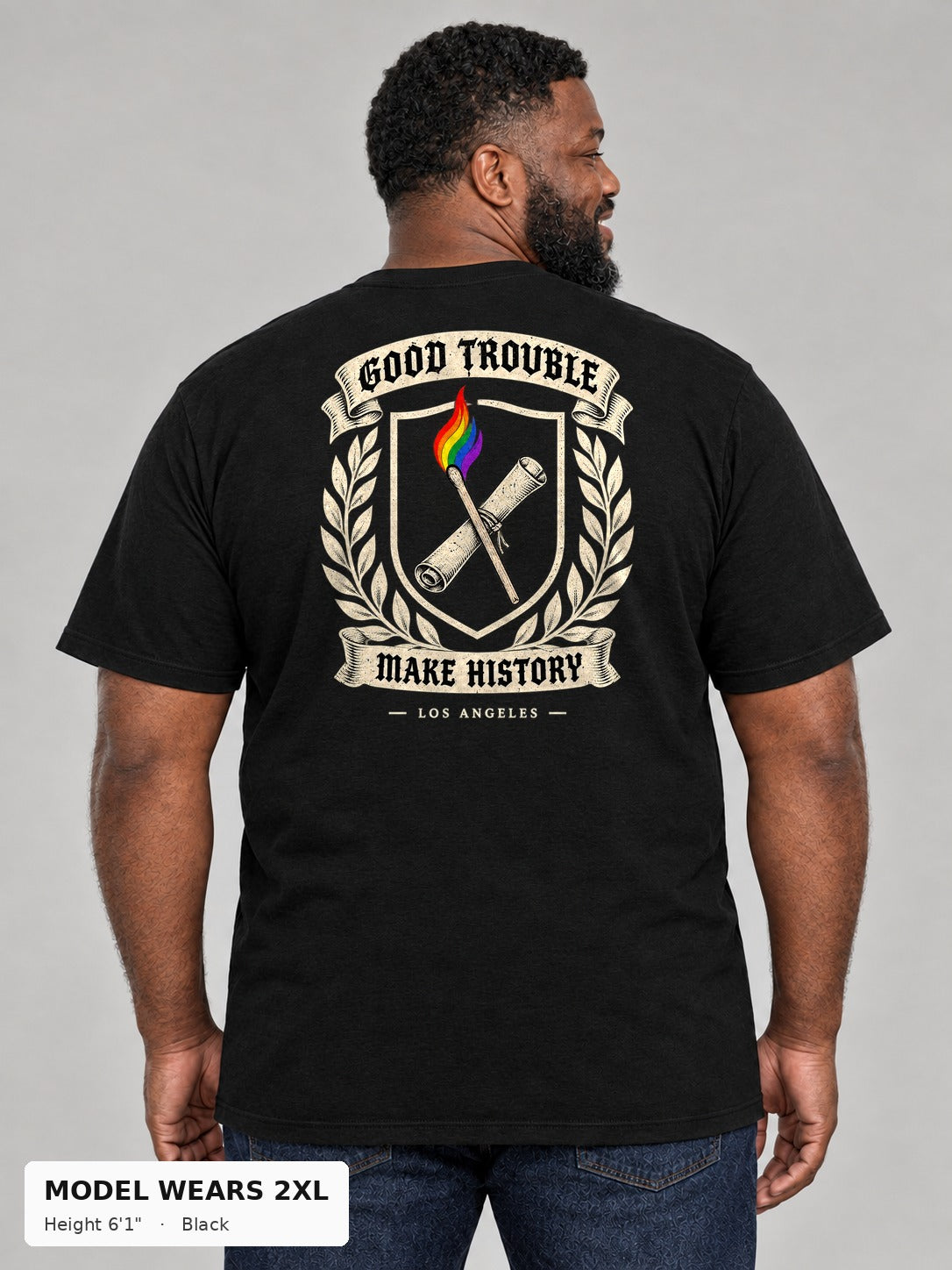 Good Trouble Heritage Crest Tee in Black, back view showing the GOOD TROUBLE Make History crest back print, on a plus-size model wearing size 2XL, 6'1" - Good Trouble Fashion