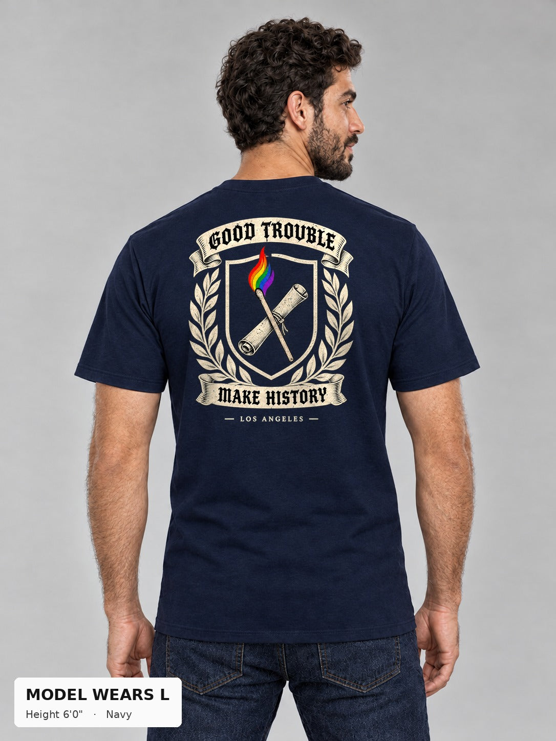 Good Trouble Heritage Crest Tee in Navy, back view showing the GOOD TROUBLE Make History crest back print, on an athletic model wearing size L, 6'0" - Good Trouble Fashion