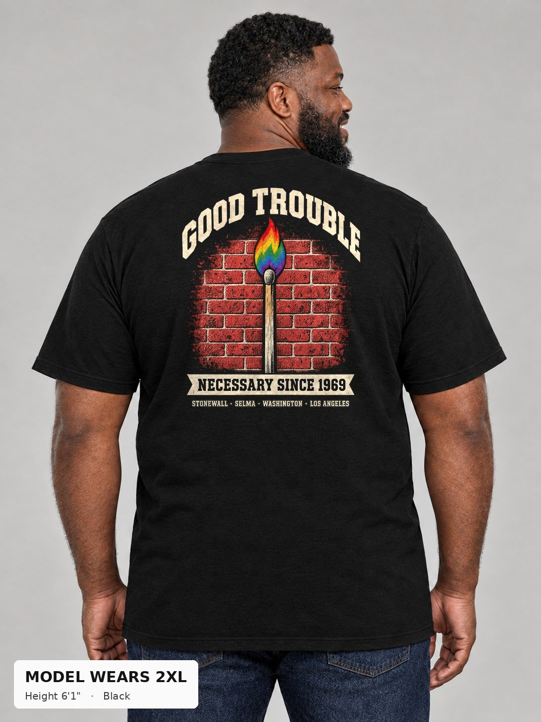 Good Trouble Necessary Since 1969 Tee in Black, back view showing the GOOD TROUBLE brick-wall match back print, on a plus-size model wearing size 2XL, 6'1" - Good Trouble Fashion