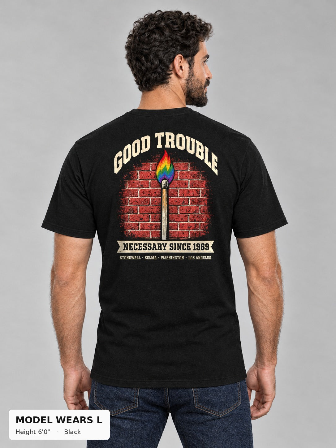 Good Trouble Necessary Since 1969 Tee in Black, back view showing the GOOD TROUBLE brick-wall match back print, on an athletic model wearing size L, 6'0" - Good Trouble Fashion