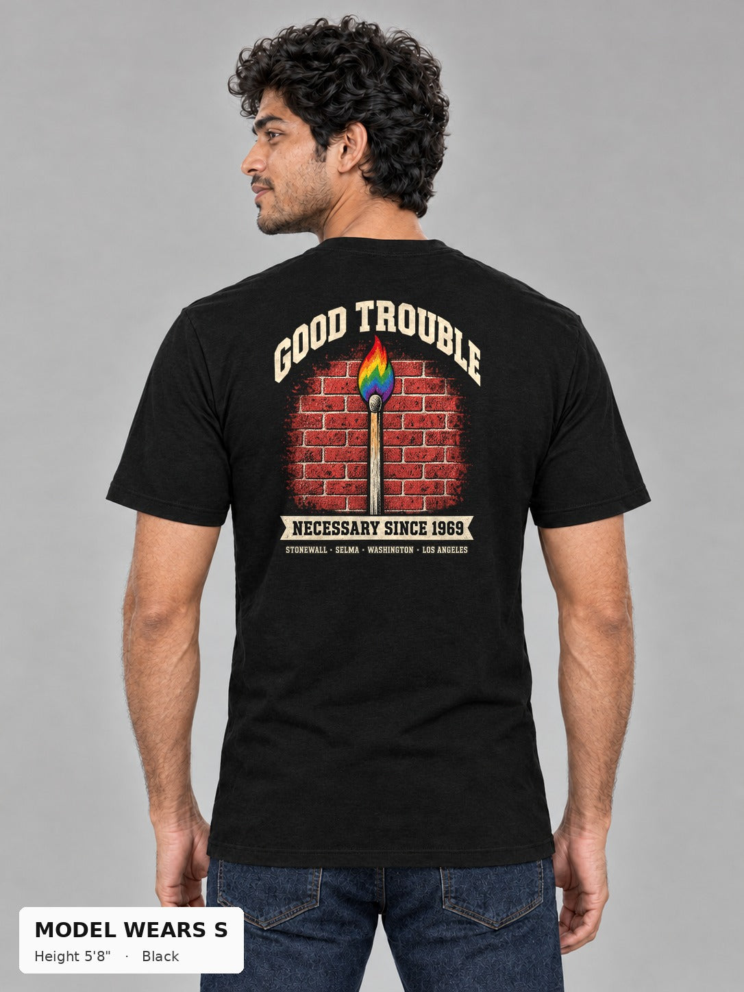 Good Trouble Necessary Since 1969 Tee in Black, back view showing the GOOD TROUBLE brick-wall match back print, on a slim model wearing size S, 5'8" - Good Trouble Fashion