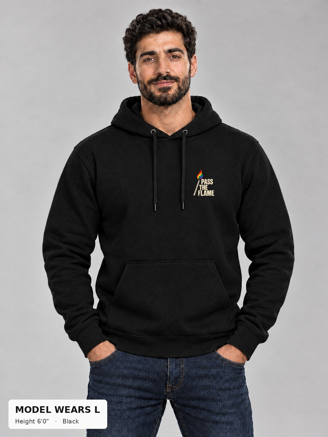 Good Trouble Pass the Flame Hoodie in Black, front view showing the Pass the Flame chest badge, on an athletic model wearing size L, 6'0" - Good Trouble Fashion