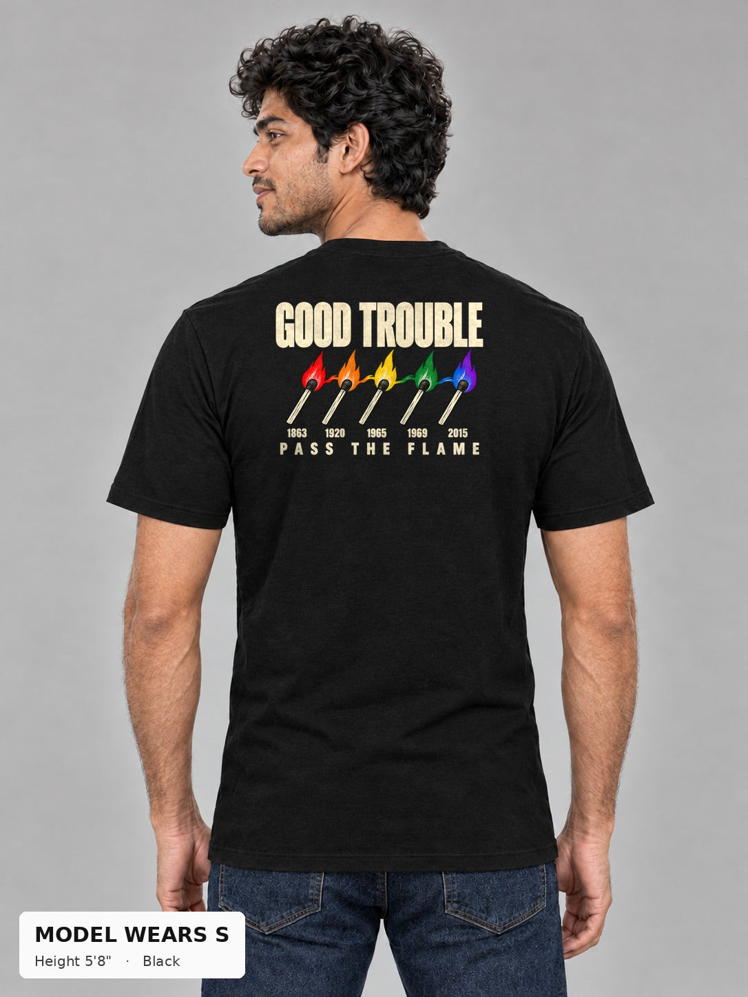 Good Trouble Pass the Flame Tee in Black, back view showing the PASS THE FLAME five-match back print, on a slim model wearing size S, 5'8" - Good Trouble Fashion