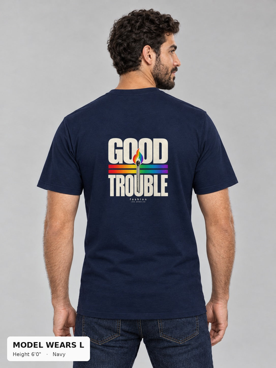 Good Trouble Spark Tee in Navy, back view showing the GOOD TROUBLE rainbow match back print, on an athletic model wearing size L, 6'0" - Good Trouble Fashion