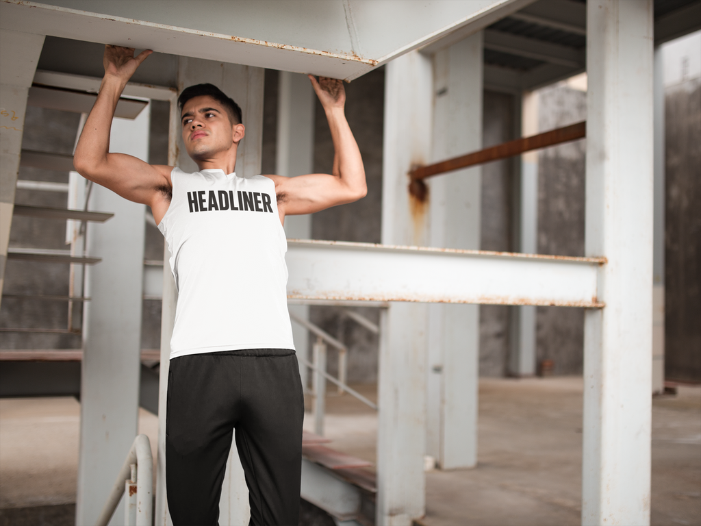 Man wearing white Headliner graphic tee by Good Trouble Fashion lifting weights in an industrial gym