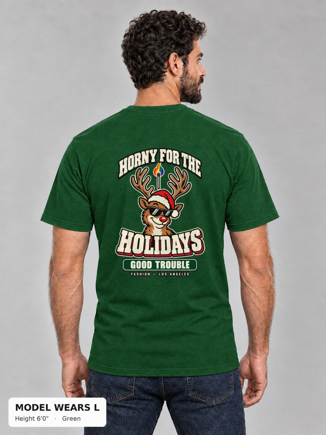 Horny for the Holidays Tee in Green, back view showing the HORNY FOR THE HOLIDAYS reindeer back print, on an athletic model wearing size L, 6'0" - Good Trouble Fashion