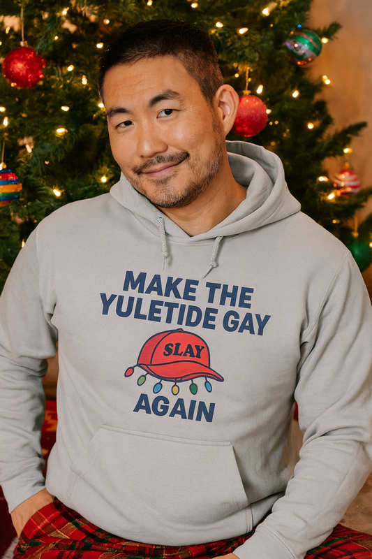 Model wearing gray hoodie with 'Make the Yuletide Gay AGAIN' slogan and festive design for holiday cheer
