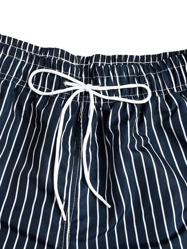 Good Trouble Garments men's striped swim shorts with navy blue and white vertical stripes and white drawstring