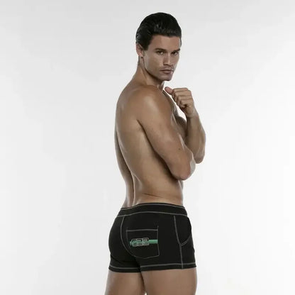 CODE 22 short black swimwear for men by Good Trouble Garments worn by male model showing back view