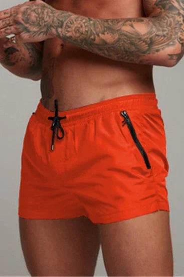 Good Trouble Garments bright orange short sexy swim trunks with black drawstring and zipper pocket