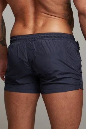 Good Trouble Garments short sexy swim trunks in black worn by male model from back view